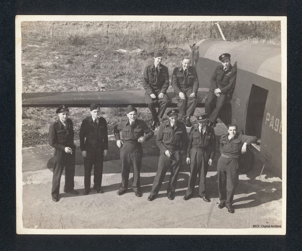 A group of aircrew and one ground crew member arranged at the rear starboard side of Lancaster PA964. Six are standing and three are sitting on the tail plane. 